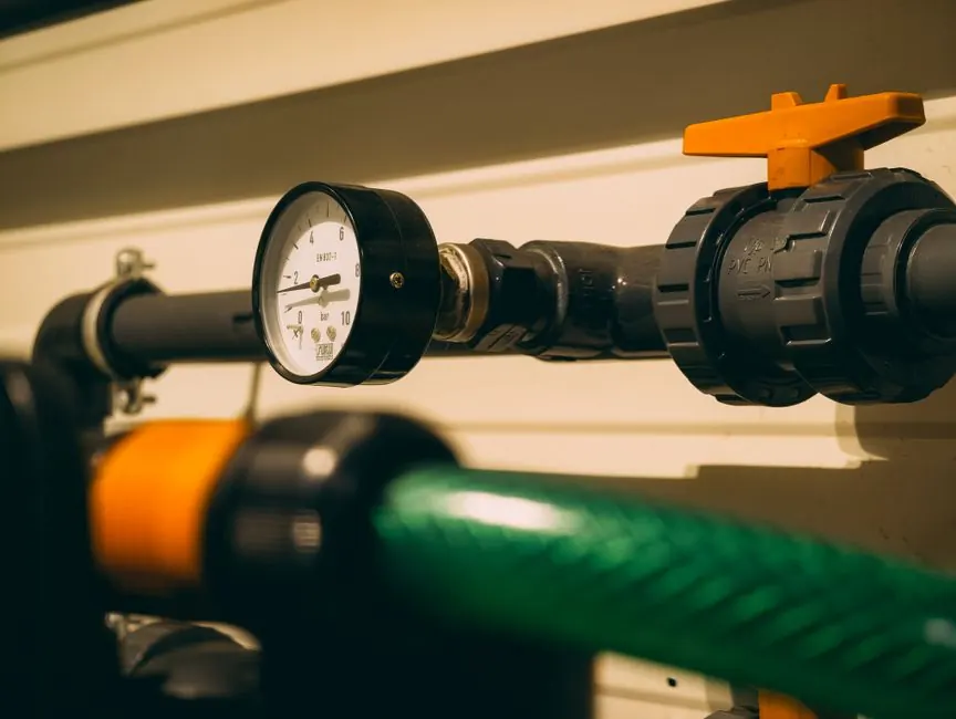 Close-up view of an industrial pressure gauge attached to piping. Ideal for engineering or industry visuals.